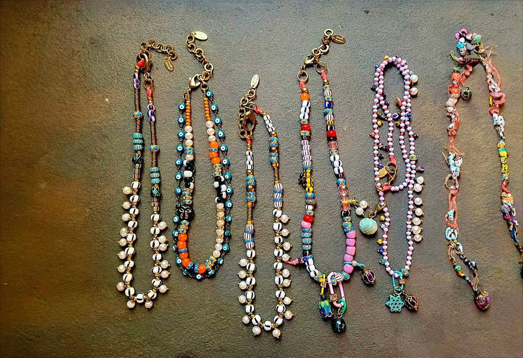Assortment of necklaces sitting on a table, including gold, silver, and gemstone necklaces.
