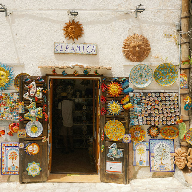 Entrée d'une boutique sicilienne avec des céramiques colorées exposées à l'extérieur