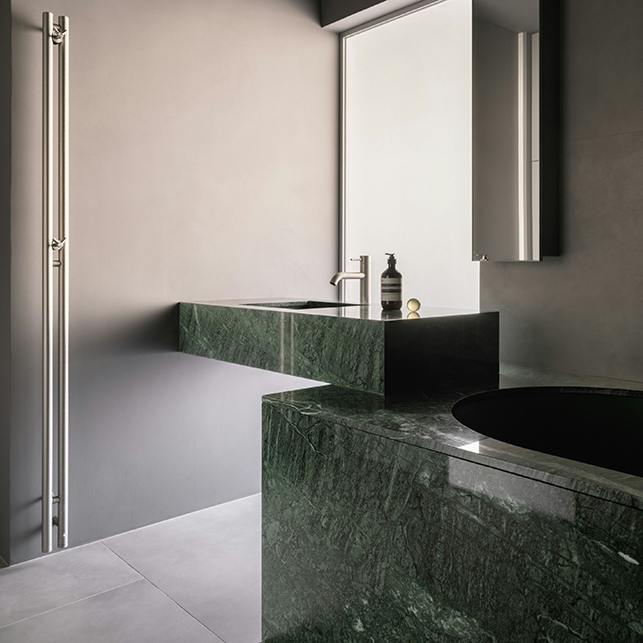 Salle de bain de conception avec en marbre vert avec revêtement et lavabo suspendu
