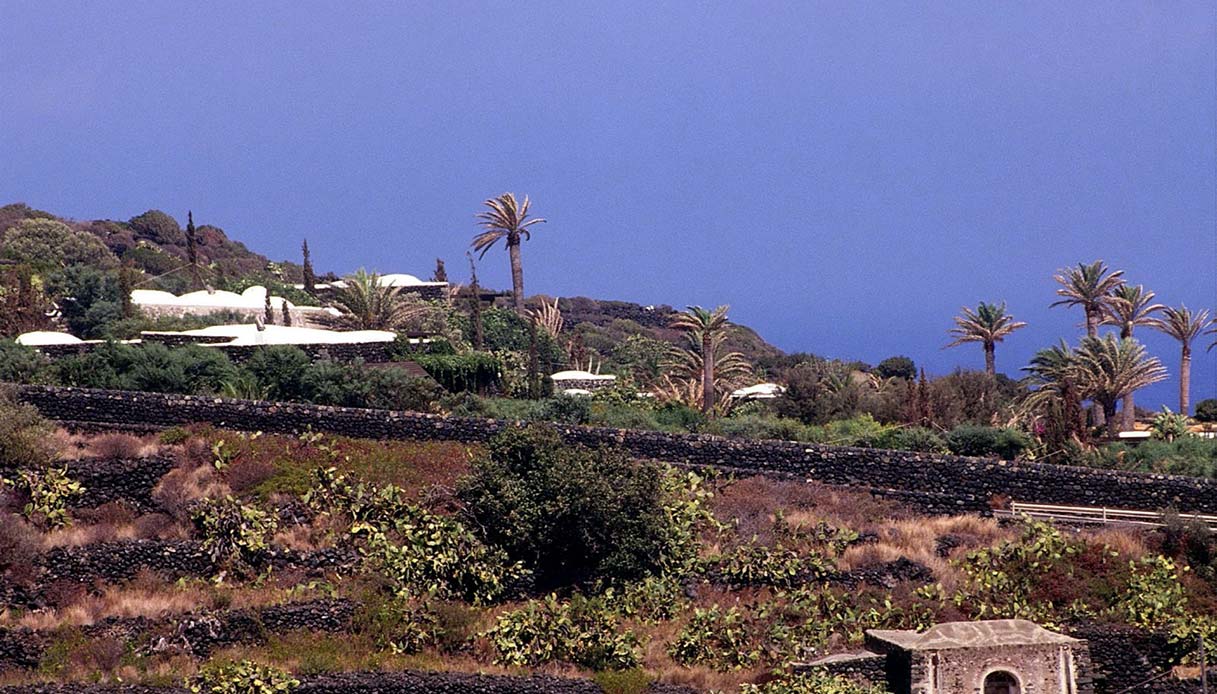Vue panoramique de la villa de Giorgio Armani à Pantelleria entourée de végétation et de palmiers