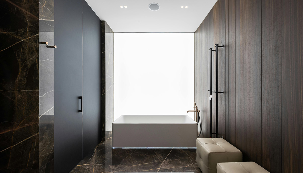Salle de bain moderne avec baignoire rectangulaire minimale, revêtement en pierre et bois foncé, style et matériau essentiels