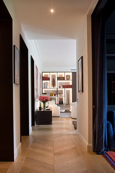 Corridor avec plancher en bois et bibliothèque rétro-éclairée dans un appartement de luxe à Brera