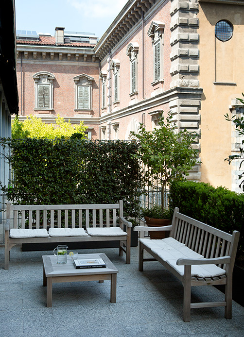 Terrasse en teck avec bancs et table surplombant le jardin botanique de Brera