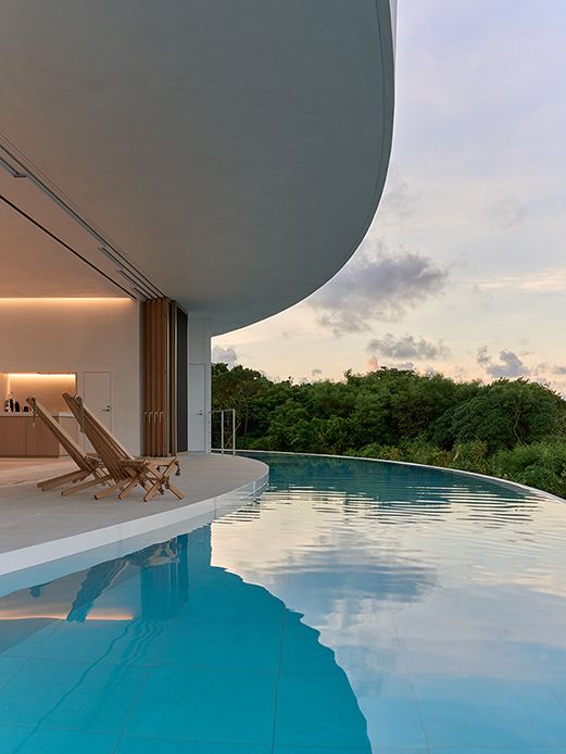 Piscine à débordement de la villa Earth au design incurvé et vue verdure